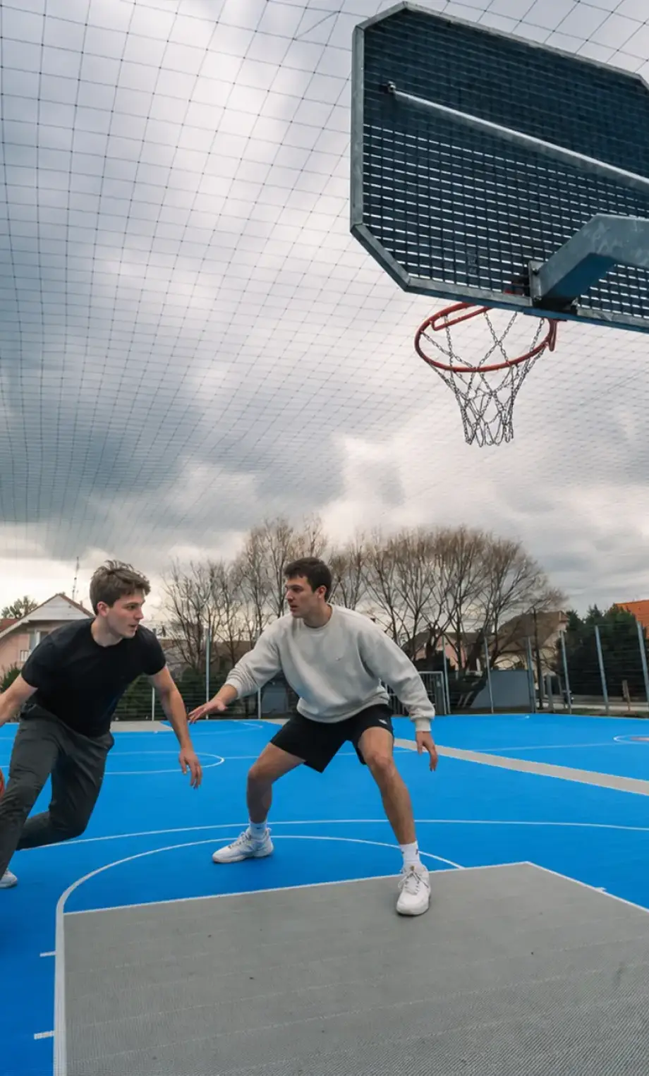 Dvaja kamaráti hrajú basketbal na ihrisku v Devínskej Novej Vsi